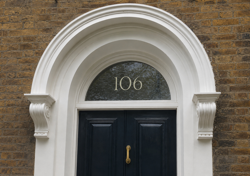Completed painted fanlight number viewed externally through the original rippled glass of a Grade II listed house.