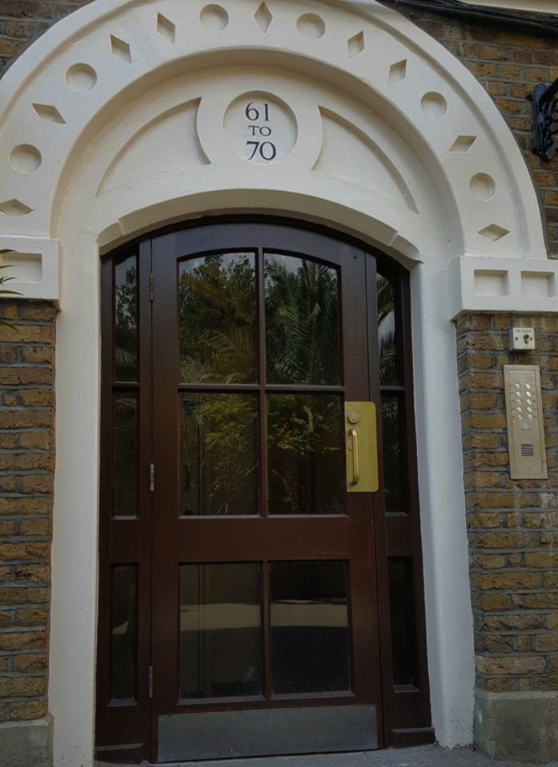 Completed entrance numbering within a recessed masonry roundel above the entrance arch.
