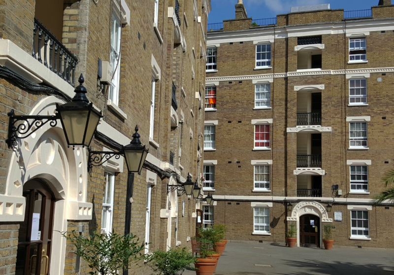 Wide view of Lumley Buildings showing multiple refurbished Victorian entrances near Sloane Square.
