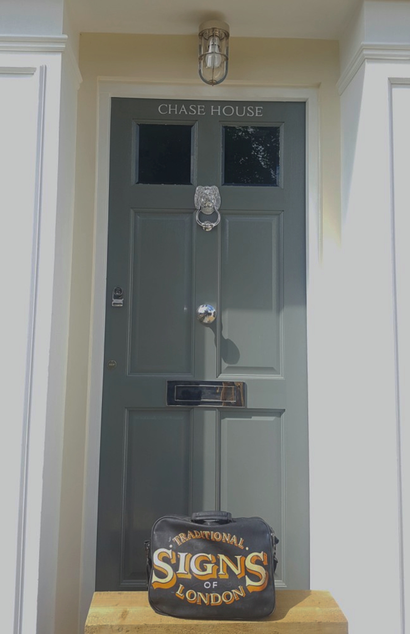 Hand painted house name on the entrance door of a period property in Enfield with traditional door furniture.
