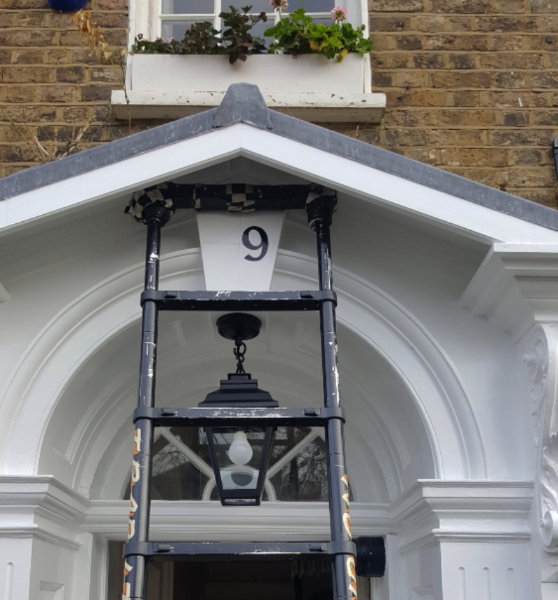 Bespoke painted house numbering centred on the entrance keystone of Westwood Cottage, a Georgian cottage built in 1794.