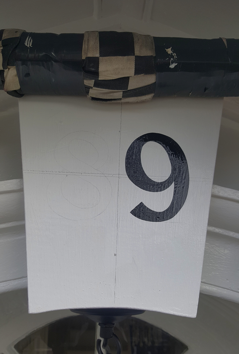 Hand painting bespoke house numbers onto the entrance keystone using traditional signwriting enamel.