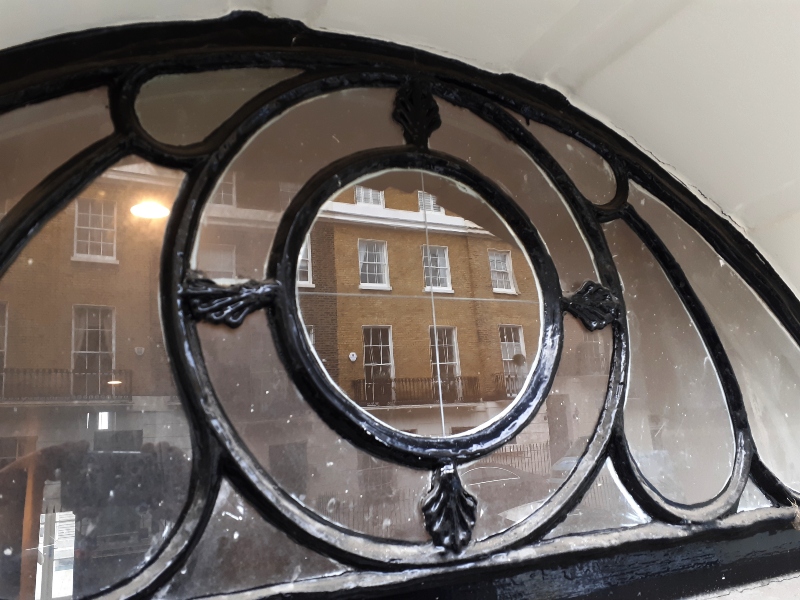 Decorative circular fanlight roundel cleaned and prepared before reverse glass water gilding at a Regency townhouse near Hyde Park.