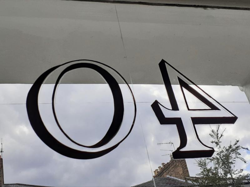 Hand painting the outlines and cast shadow on the reverse of the fanlight glass before gilding.