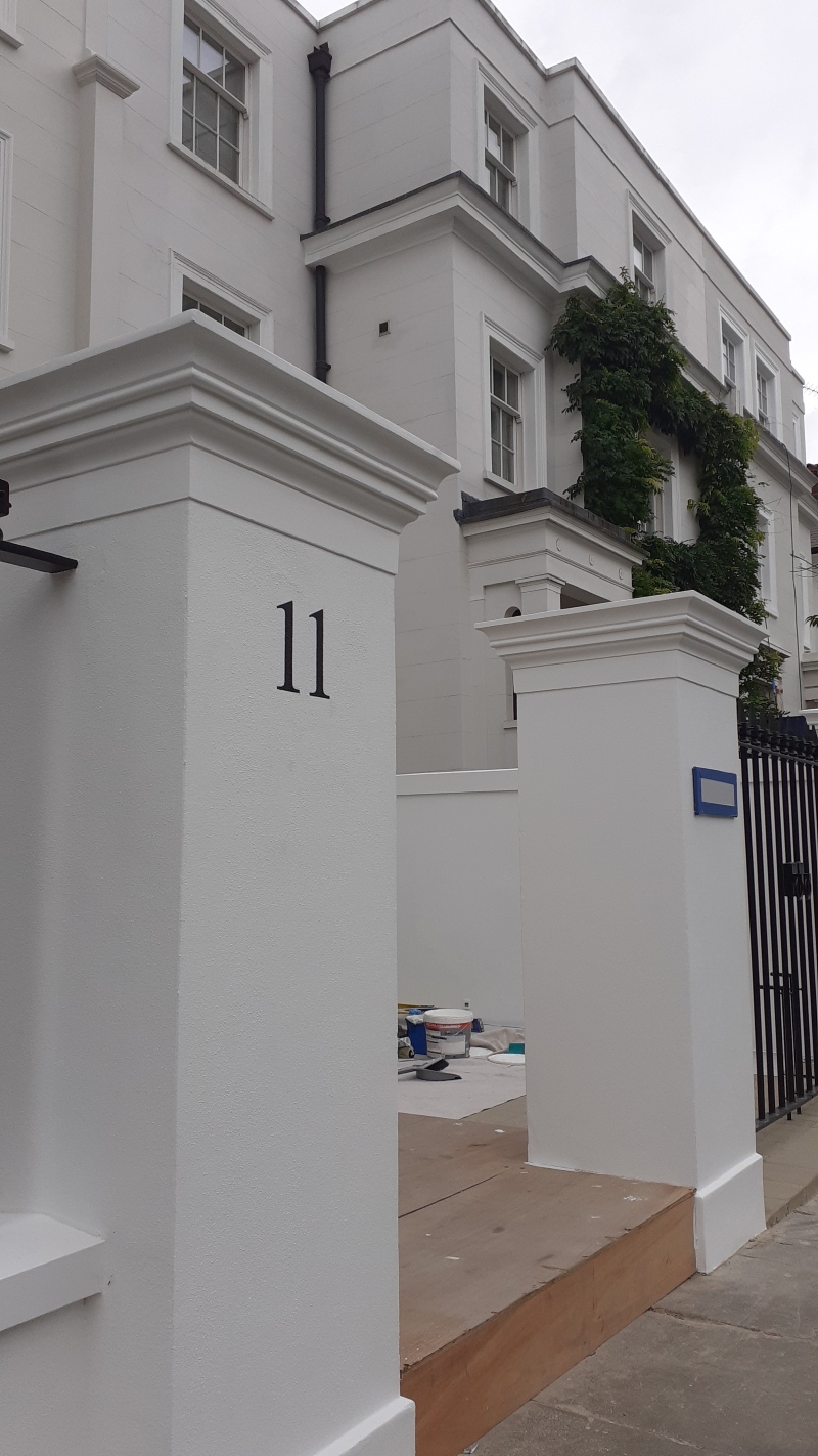Hand painted house number on a rendered entrance pier providing refined architectural property identification.