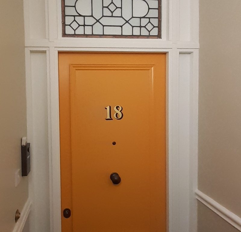 Completed genuine gold leaf architectural door numbering on the entrance of a period apartment in Bayswater.