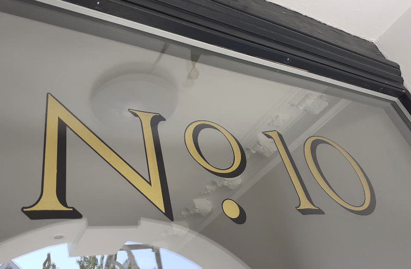 Completed genuine gold leaf architectural entrance numbering viewed from the exterior of a period residence.