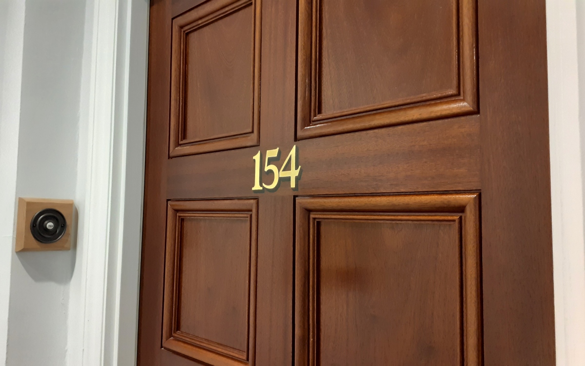 Gold leaf apartment door numbering on hardwood entrance door