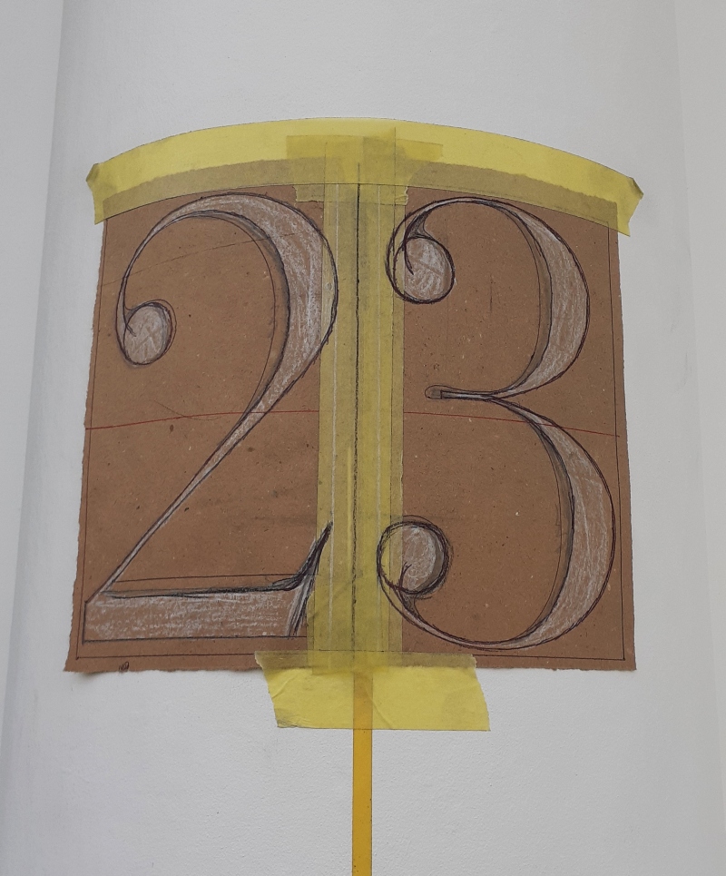Hand painted masonry pillar lettering beside entrance doorway