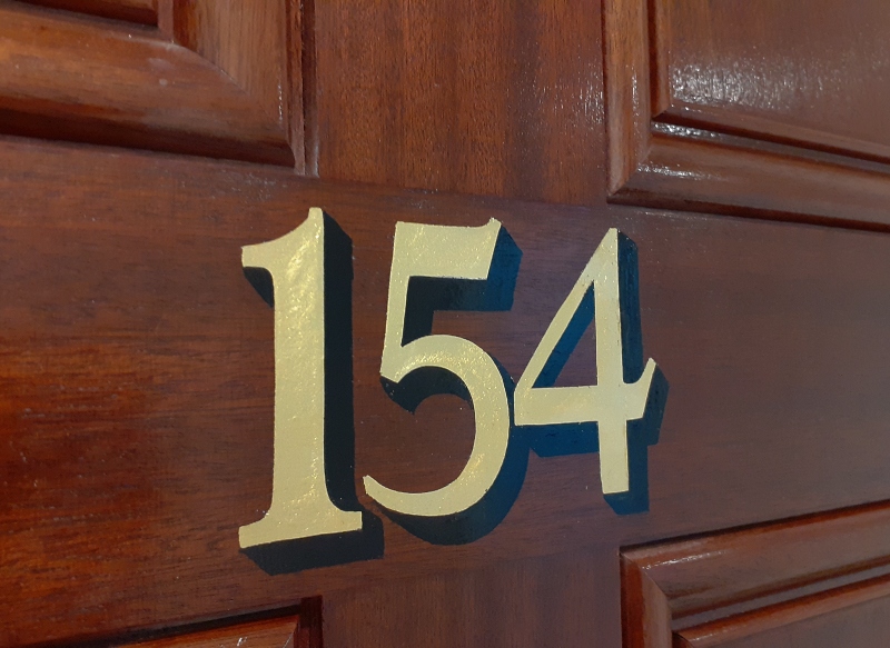 Traditional oil gilded apartment door numbering in Central London
