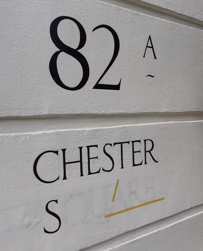 Architectural address lettering painted onto stucco wall