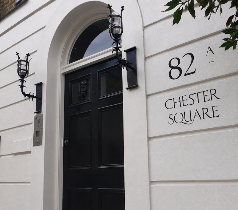 Hand painted address lettering on Belgravia stucco façade