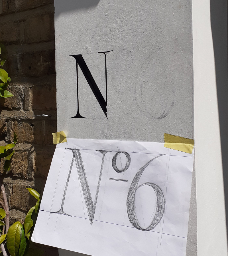 Traditional exterior property lettering painted onto masonry entrance pillar