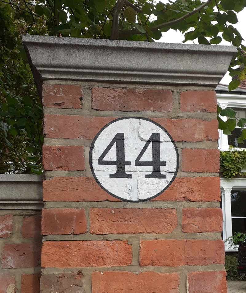 Hand painted house numbers on traditional brick gate piers in London