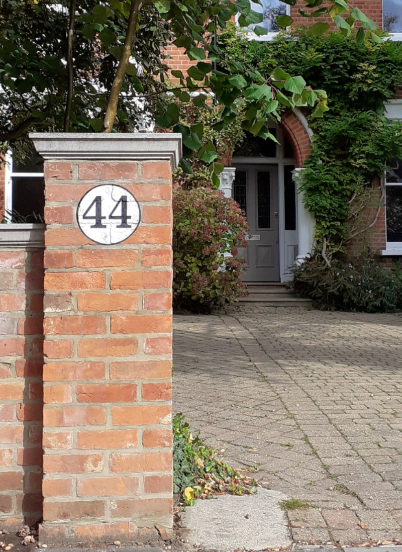 Hand painted property numbers on brick gate piers in London