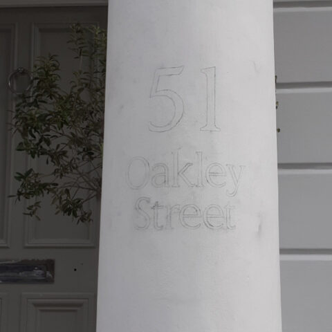 Hand painted signwriting process on masonry property surface
